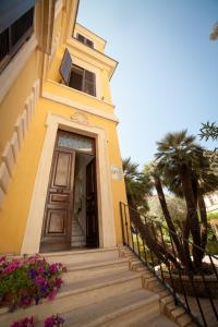 una casa amarilla con escaleras que conducen a una puerta en Villa Paganini B&B, en Roma