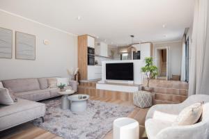 a living room with a couch and a tv at Villa Axel in Primošten