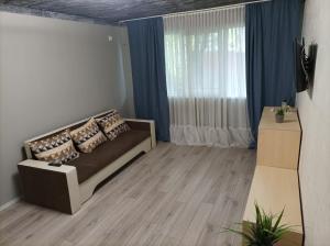 ein Wohnzimmer mit einem Sofa und einem Fenster in der Unterkunft Centrul Vechi Aparthotel in Brăila