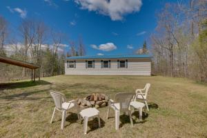 a group of chairs and a fire pit in front of a house at Cozy Midcoast Vacation Rental Near Waterville! 