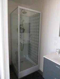 um chuveiro com uma porta de vidro na casa de banho em Gîte de la Perigourdine em Pineuilh