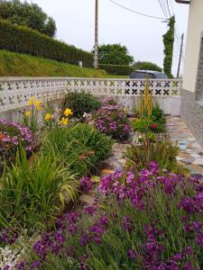 ogród z fioletowymi kwiatami i białym płotem w obiekcie Casa Pozo das Leiras (Derecha) w mieście Ares