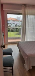a bedroom with a bed and a large window at Cosy in Saint-Jean-de-Luz