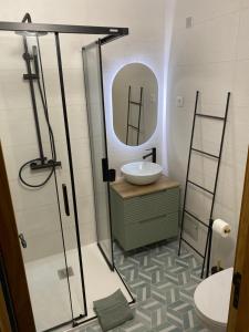 ein Bad mit einem Waschbecken und einem Spiegel in der Unterkunft Apartamento flor de amendoeira in Albufeira