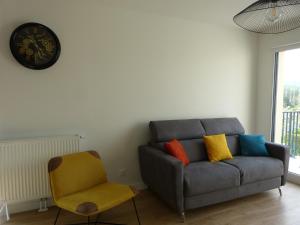 a living room with a couch and a chair at Le colibri in Houlgate