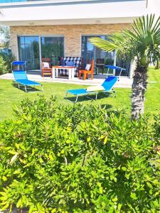 2 chaises bleues, une table et un palmier dans l'établissement Luxury Apartment Slavica by the sea,with garden, à Sukošan