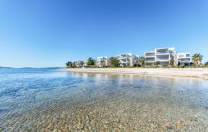 - une vue sur la plage avec des maisons en arrière-plan dans l'établissement Luxury Apartment Slavica by the sea,with garden, à Sukošan