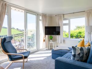un soggiorno con divano blu e TV di Grand View a Hope Cove