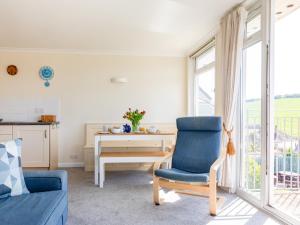 sala de estar con silla azul y escritorio en Grand View, en Hope-Cove