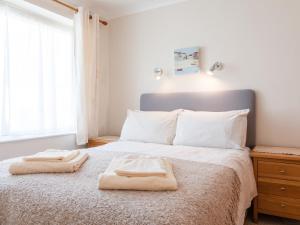 una camera da letto con un letto e due asciugamani di Grand View a Hope Cove