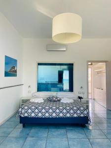 a bedroom with a large bed with a large window at Capo Nettuno Hotel in Capo dʼOrlando