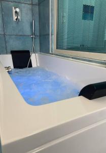 a bath tub filled with blue water in a room at Capo Nettuno Hotel in Capo dʼOrlando