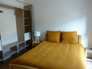 una camera da letto con un letto con lenzuola gialle e una finestra di Le colibri a Houlgate