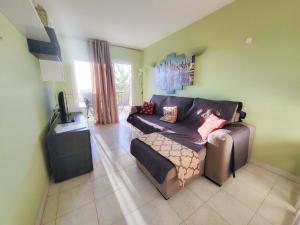 ein Wohnzimmer mit einem Sofa und einem TV in der Unterkunft eldorado blue in Playa de las Americas