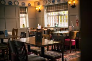 a dining room with tables and chairs in a restaurant at Three Horseshoes Inn in Durham