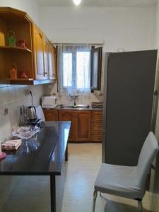 a kitchen with a table and a chair in it at Kiki Apartment in Naxos Chora +12 photos
