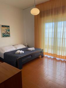 a bedroom with a bed in front of a window at Capo Nettuno Hotel in Capo dʼOrlando