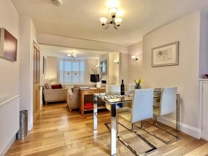 a dining room and living room with a table and chairs at Wickland Cottage in Chichester