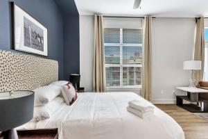 a bedroom with a large white bed and a window at Modern 1BR CozySuites with pool, gym, parking #02 in Dallas