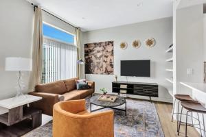 a living room with a couch and a tv at Modern 1BR CozySuites with pool, gym, parking #02 in Dallas