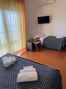 Habitación de hotel con cama y toallas en el suelo en Capo Nettuno Hotel, en Capo dʼOrlando