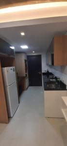 a kitchen with a black door and a white refrigerator at Edificio Flats del sol in Asuncion