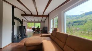 a living room with a couch and a large window at Maal Waldhaus in Todtnau +24 photos