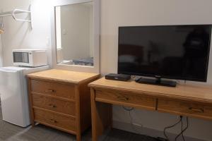 a television on a wooden dresser with a dresser with a dresserngth at Grandview Motel in Kamloops