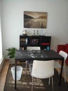 comedor con mesa negra y sillas blancas en City Apartment Tübingen-Lustnau en Tübingen