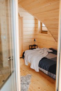 a bedroom with a bed in a wooden cabin at Dziki Raj in Jabłonka