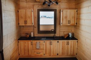 a kitchen with a sink and a window in a cabin at Dziki Raj in Jabłonka