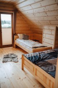 a room with three beds in a wooden cabin at Dziki Raj in Jabłonka