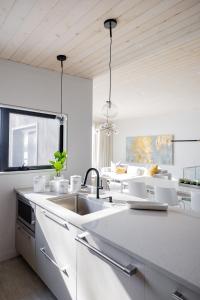 eine weiße Küche mit einem Waschbecken und weißen Geräten in der Unterkunft 4 Bedroom Lakefront House by Leavetown Vacations in Lakefield