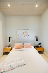 ein Schlafzimmer mit einem großen weißen Bett mit zwei rosa Kissen in der Unterkunft 4 Bedroom Lakefront House by Leavetown Vacations in Lakefield