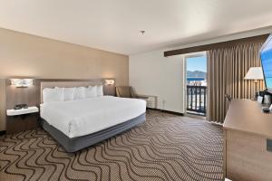 una habitación de hotel con una cama y un balcón en Cedar Street Hotel & Suites, en Sandpoint