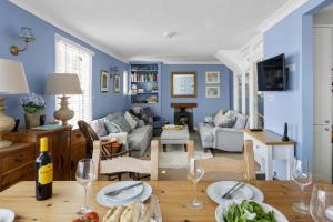 ein Wohnzimmer mit blauen Wänden und einem Tisch mit Weingläsern in der Unterkunft The Admiralty Wash House in Dartmouth