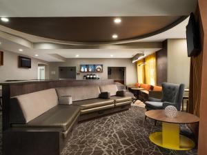 a living room with a couch and a table at SpringHill Suites Kansas City Overland Park in Overland Park
