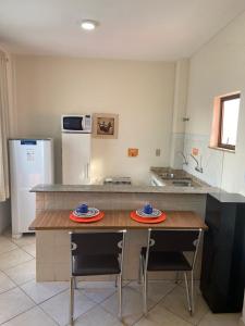 a kitchen with a table with two plates on it at Apart Victoria in Vitória da Conquista