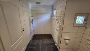 een badkamer met een deur en een betegelde gang bij Maal Waldhaus in Todtnau