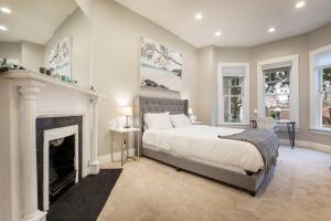1 dormitorio con 1 cama grande y chimenea en TWO Units, Entire Stylish Home by CozySuites, en Louisville