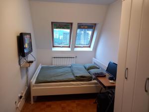 a small bedroom with a bed and a desk with a computer at Apartment 075 in Tuzla
