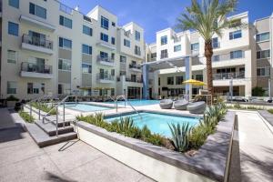 a swimming pool in front of a apartment building at Modern CozySuites - paradise under the palm trees! in Phoenix