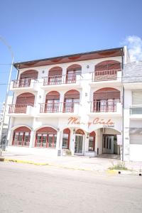 a white building with red writing on the side of it at Mar y Cielo in Necochea