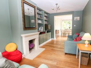 a living room with a fireplace and a mirror at 3 Painters Field in Cirencester