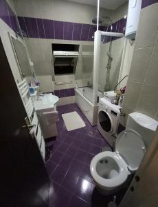 a bathroom with a toilet and a sink and a tub at Apartment 075 in Tuzla
