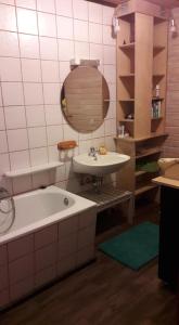 a bathroom with a tub and a sink and a mirror at Ferienhaus Neumühle in Lutzerath