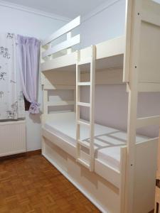 a white bunk bed in a room with a window at Euphoria beach house in Paleo Tsifliki