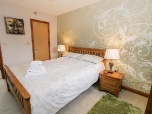 um quarto com uma cama e duas lâmpadas sobre uma mesa em 6 Stad Yr Ysgol em Blaenau-Ffestiniog