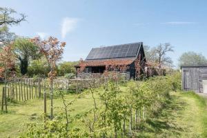 an old barn with solar panels on its roof at Yoxford Farm Hayloft in Saxmundham