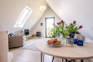 a table with a plate of food on it in a living room at Yoxford Farm Hayloft in Saxmundham